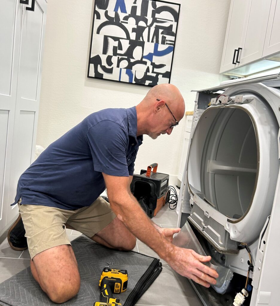 Professional appliance repair technician servicing a dryer in Queen Creek