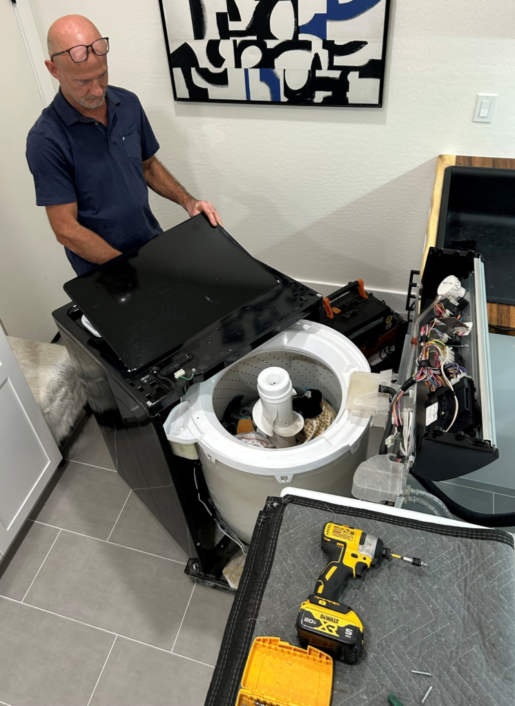 Professional appliance repair technician fixing a washing machine in Queen Creek